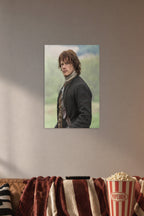 Jamie Fraser (Sam Heughan) from Outlander in a cozy movie room above a brown sofa with popcorn.