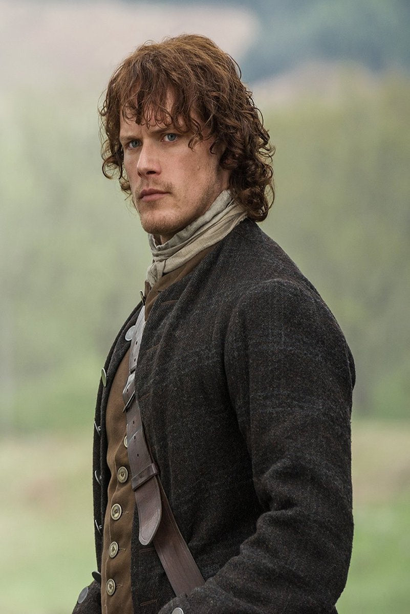 Jamie Fraser poster features a close portrait of Sam Heughan in a dark coat, brown waistcoat, scarf, and leather strap against a soft green landscape.