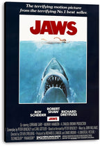 Jaws movie poster canvas wall art featuring a swimmer over an open-mouthed shark, red title lettering, and dark navy border.