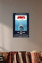 Jaws Movie Poster in a cozy movie room above a brown sofa with popcorn.