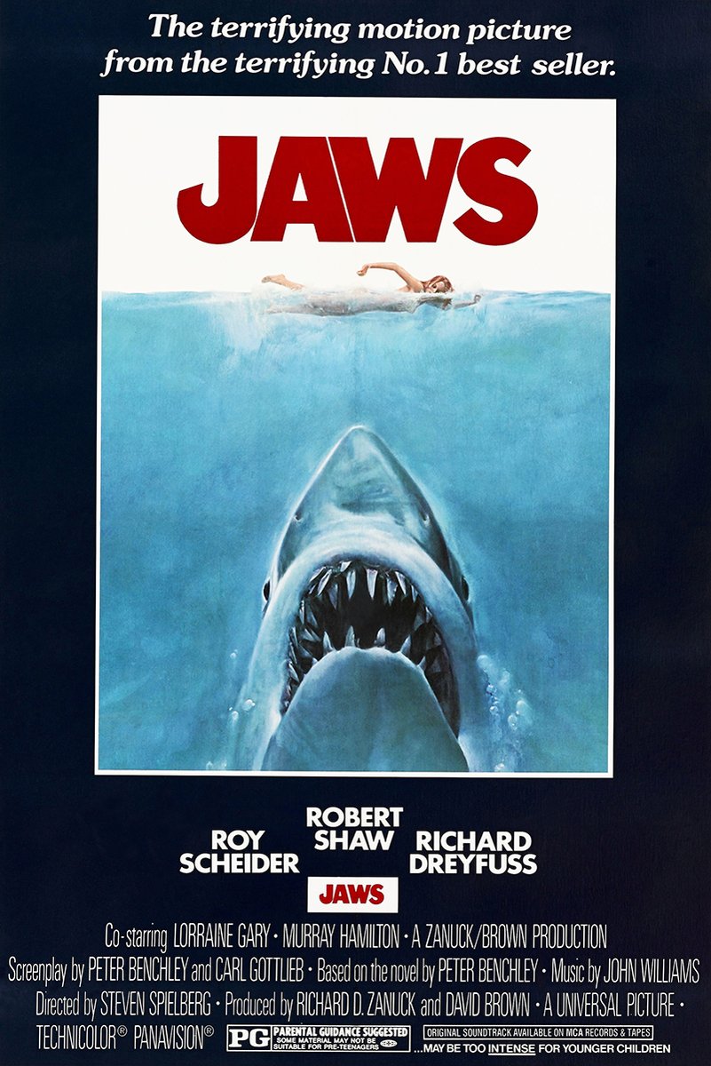 Jaws movie poster wall art with bold red title, a swimmer above a great white shark in blue water, and navy credits border.