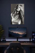 Jennifer Aniston in a gaming desk setup above a monitor.