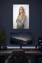 Jennifer Lawrence in a gaming desk setup above a monitor.