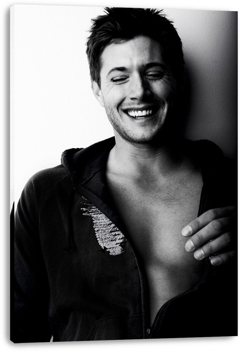 Jensen Ackles canvas wall art print presents a monochrome portrait of the smiling actor in an unzipped dark hoodie.