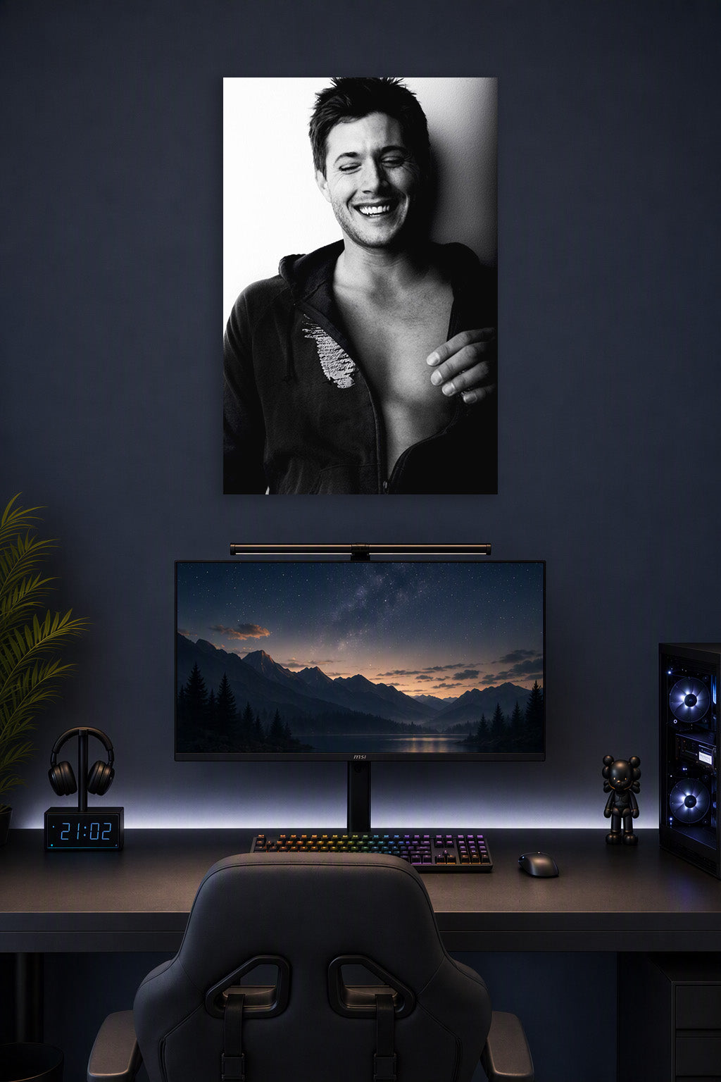 Jensen Ackles in a gaming desk setup above a monitor.