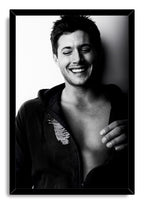 Jensen Ackles framed wall art print displays a black-and-white portrait of the actor smiling broadly with eyes closed.