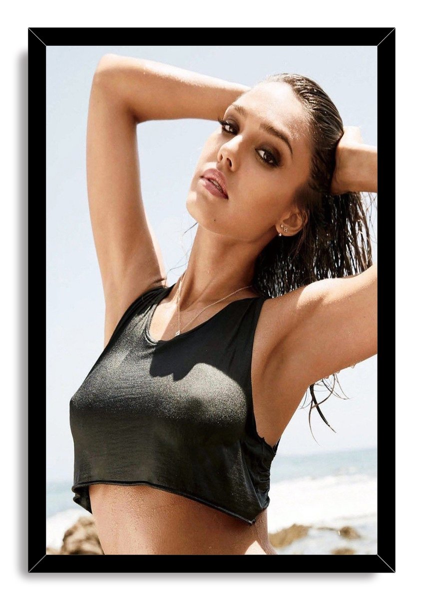 Jessica Alba framed wall art print portraying her with raised arms and wet hair in a black crop top by the sea.