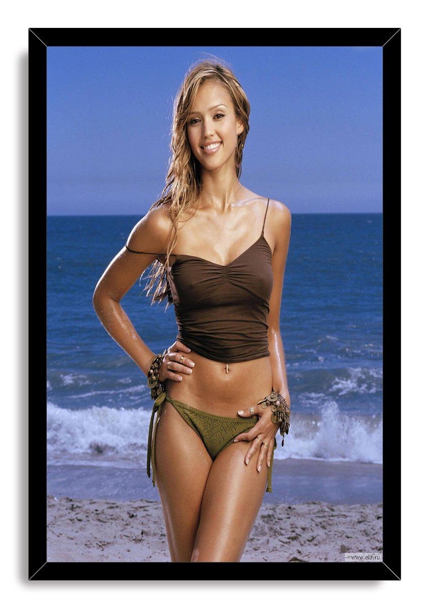 Jessica Alba framed wall art print portrays her smiling in brown and olive beachwear on a shoreline, set in a black frame.