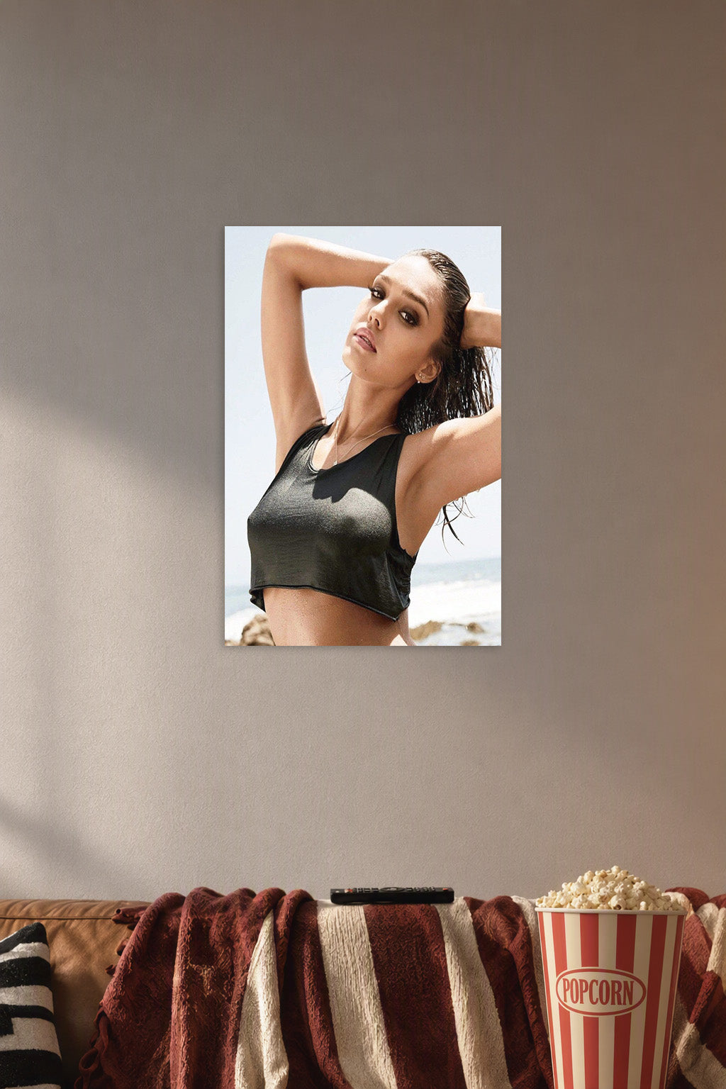 Jessica Alba in a cozy movie room above a brown sofa with popcorn.
