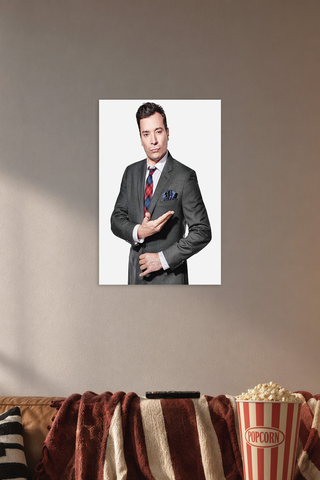 Jimmy Fallon in a cozy movie room above a brown sofa with popcorn.
