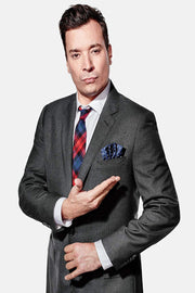 Jimmy Fallon poster portrait in a gray suit, plaid red and blue tie, and navy pocket square against white.