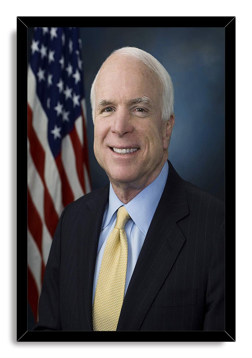 John McCain framed wall art print featuring his formal portrait, yellow tie, dark suit, and American flag against blue-gray.