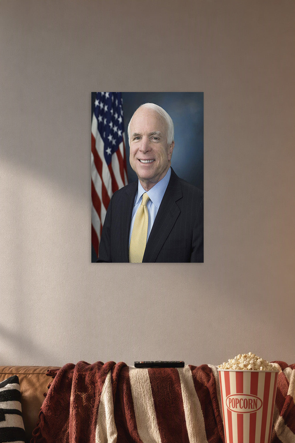 John McCain in a cozy movie room above a brown sofa with popcorn.