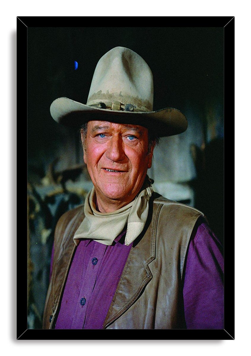 John Wayne framed wall art print with a cowboy hat portrait, cream neckerchief, brown vest, and purple shirt.