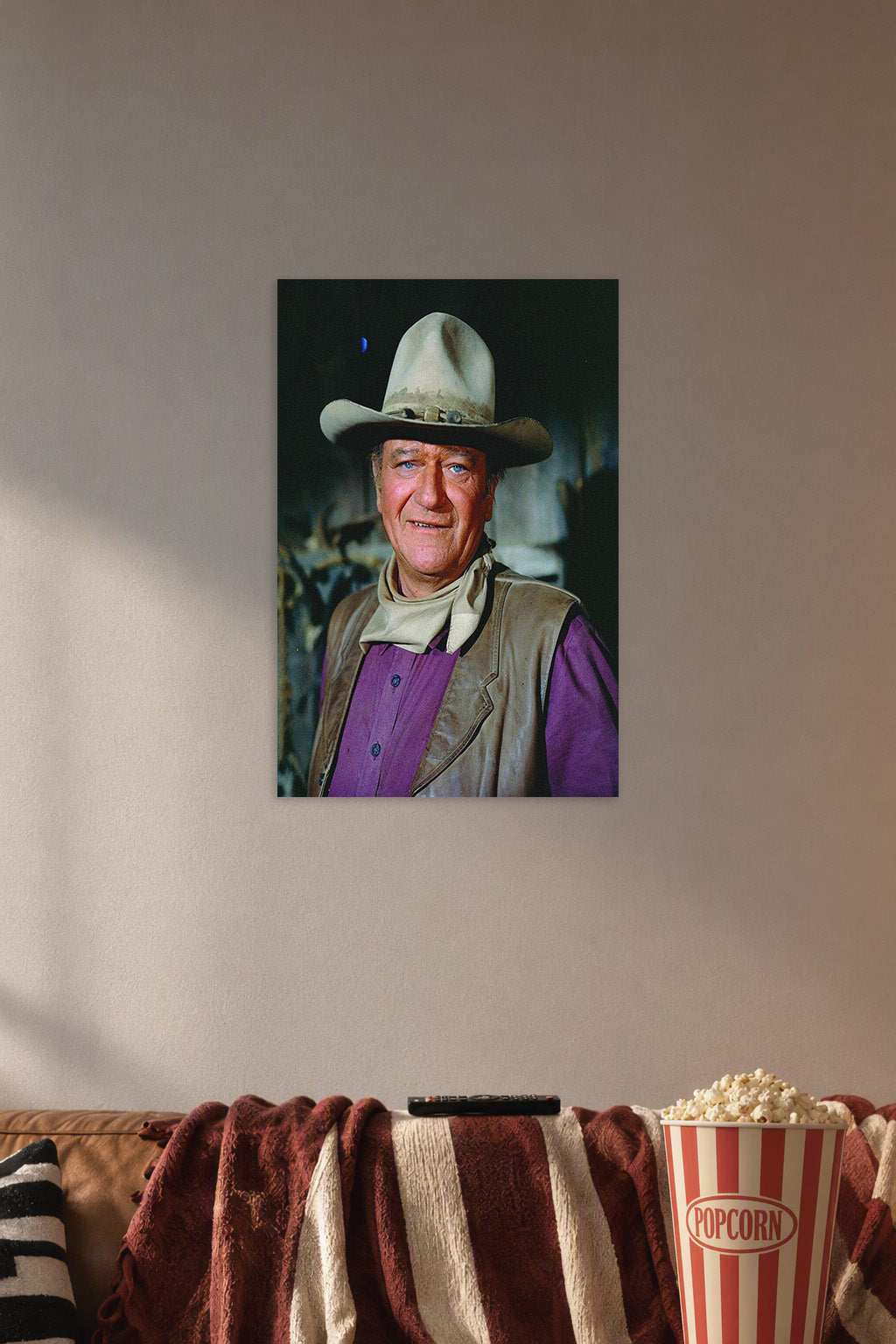 John Wayne in a cozy movie room above a brown sofa with popcorn.