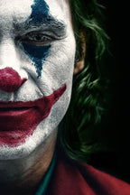 Joker wall art print features a close-up portrait with white face paint, blue eye makeup, red smile, and green hair on black.