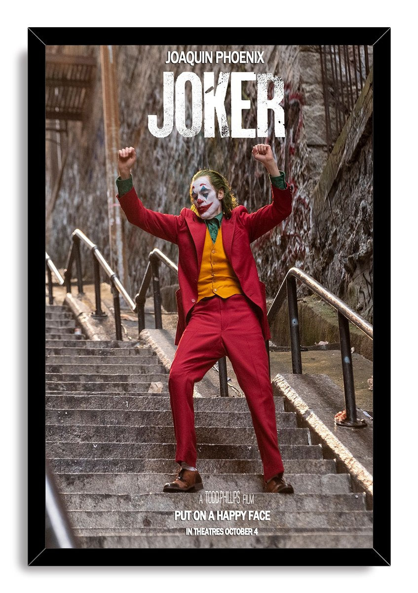 Joker framed wall art print portrays Joaquin Phoenix in a red suit and clown makeup dancing on stairs within a black frame.
