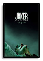 Joker framed wall art print features a black frame around Joaquin Phoenix in makeup against a shadowy teal backdrop.