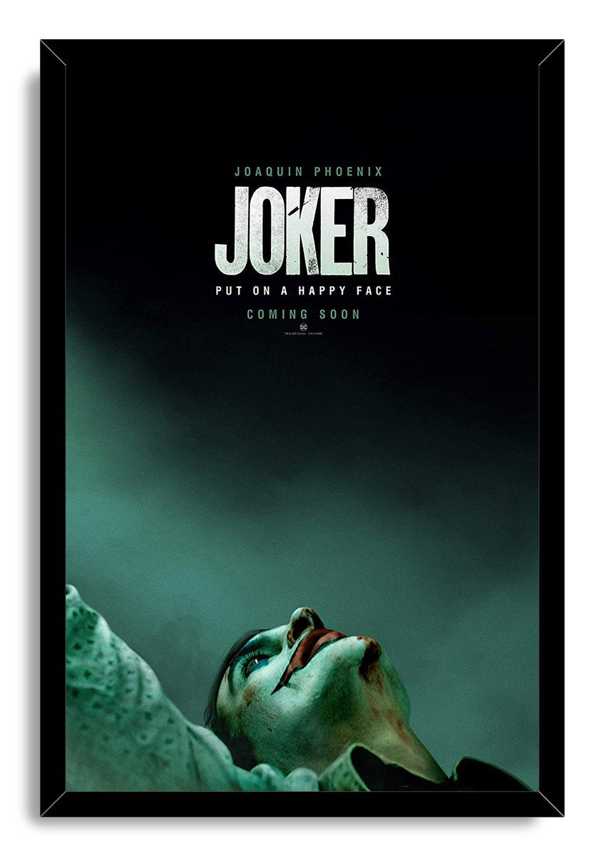 Joker framed wall art print features a black frame around Joaquin Phoenix in makeup against a shadowy teal backdrop.