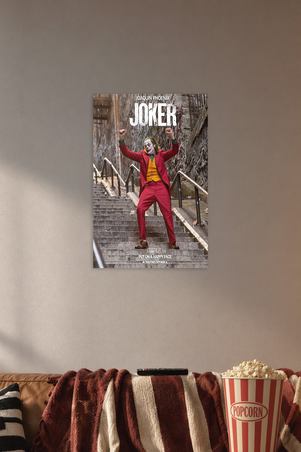 Joker Joaquin Phoenix in a cozy movie room above a brown sofa with popcorn.