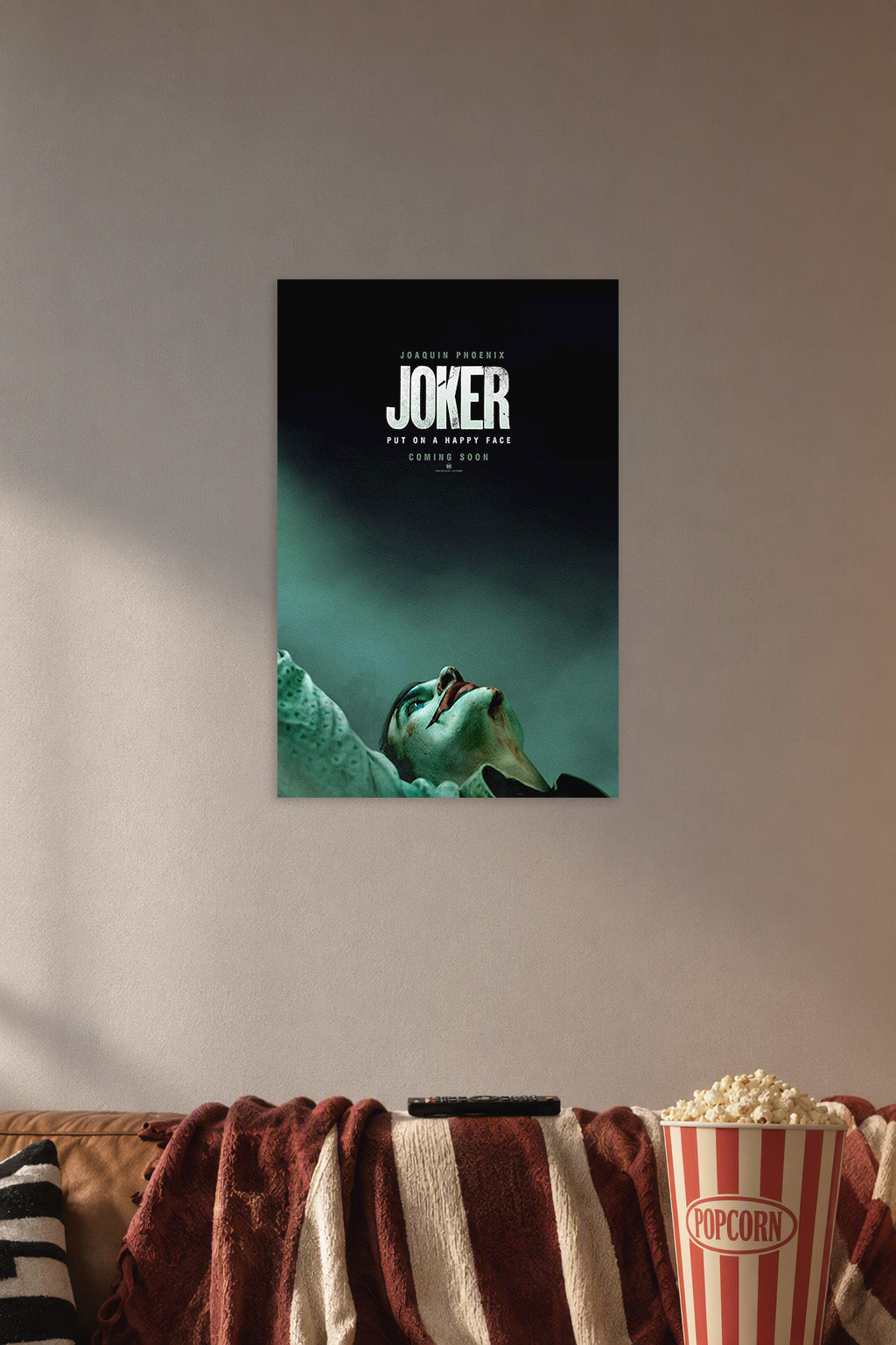 Joker (Joaquin Phoenix) in a cozy movie room above a brown sofa with popcorn.