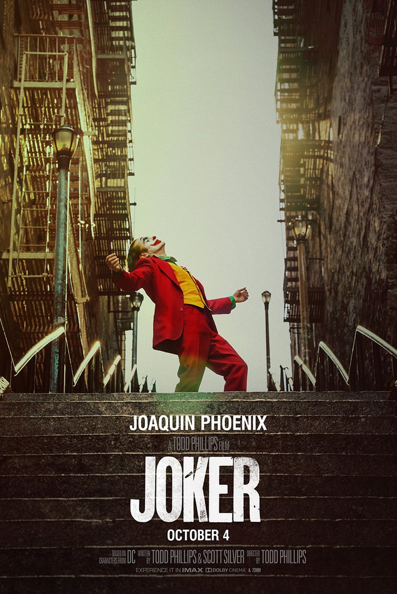Joker poster features Joaquin Phoenix dancing on a city stairway in a red suit, framed by fire escapes and street lamps.