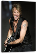 Jon Bon Jovi canvas wall art print features the grinning guitarist in a black leather vest against a dark concert backdrop.