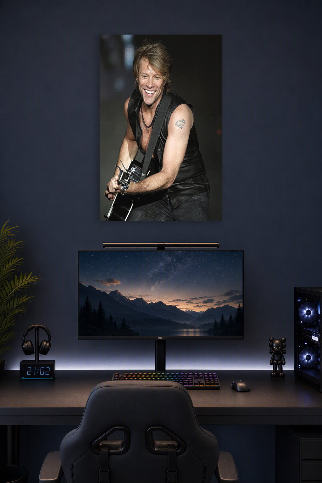 Jon Bon Jovi in a gaming desk setup above a monitor.
