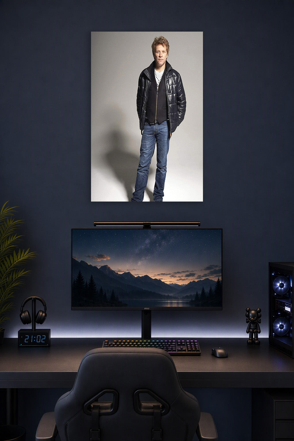 Jon Bon Jovi in a gaming desk setup above a monitor.