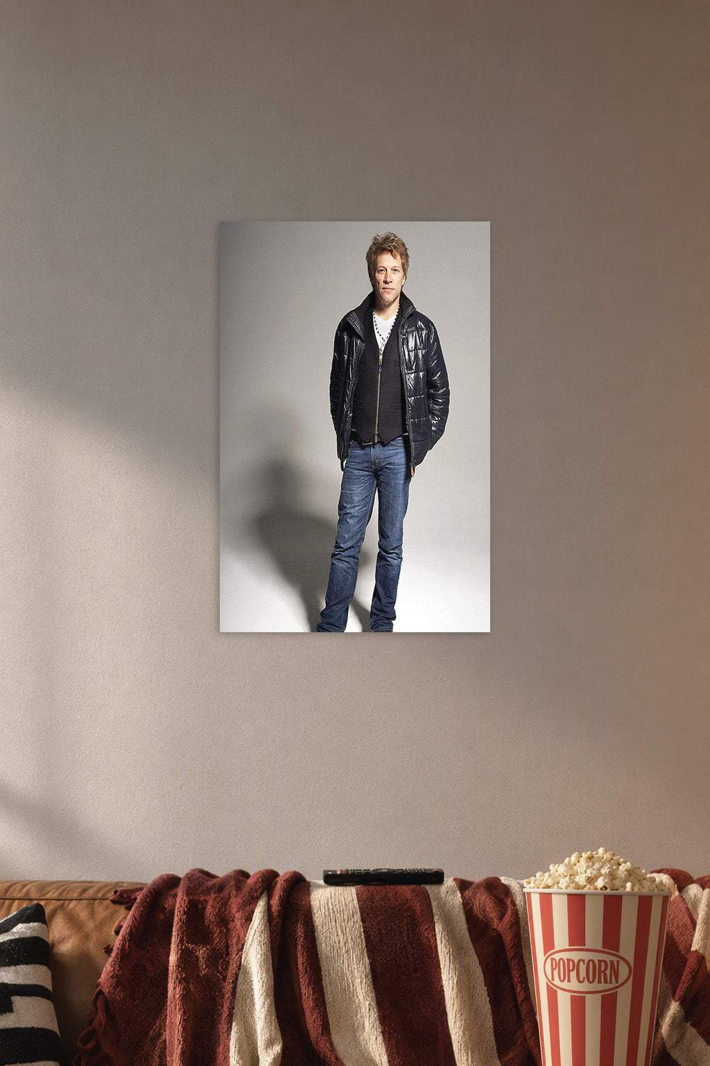 Jon Bon Jovi in a cozy movie room above a brown sofa with popcorn.