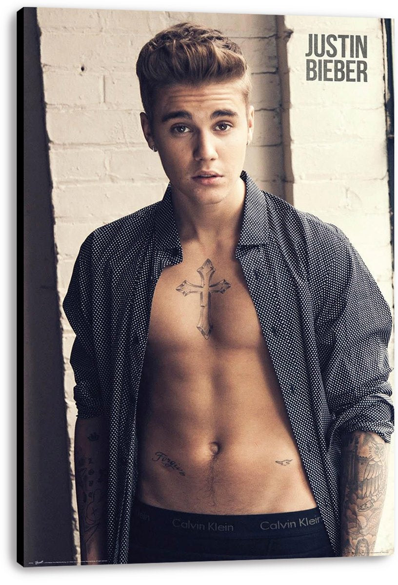Justin Bieber canvas wall art print presents the singer in an open black patterned shirt against a pale brick wall.