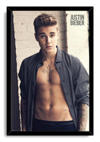 Justin Bieber framed wall art print features a portrait of the singer with chest and arm tattoos in a black frame.