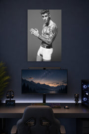 Justin Bieber in a gaming desk setup above a monitor.