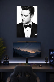 Justin Timberlake in a gaming desk setup above a monitor.