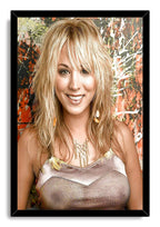 Kaley Cuoco framed wall art print with a black border, her blonde portrait, gold necklace, and orange abstract background.