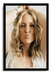 Kate Hudson framed wall art print in a black border, portraying her with tousled blonde hair, raised arms, and pursed lips.