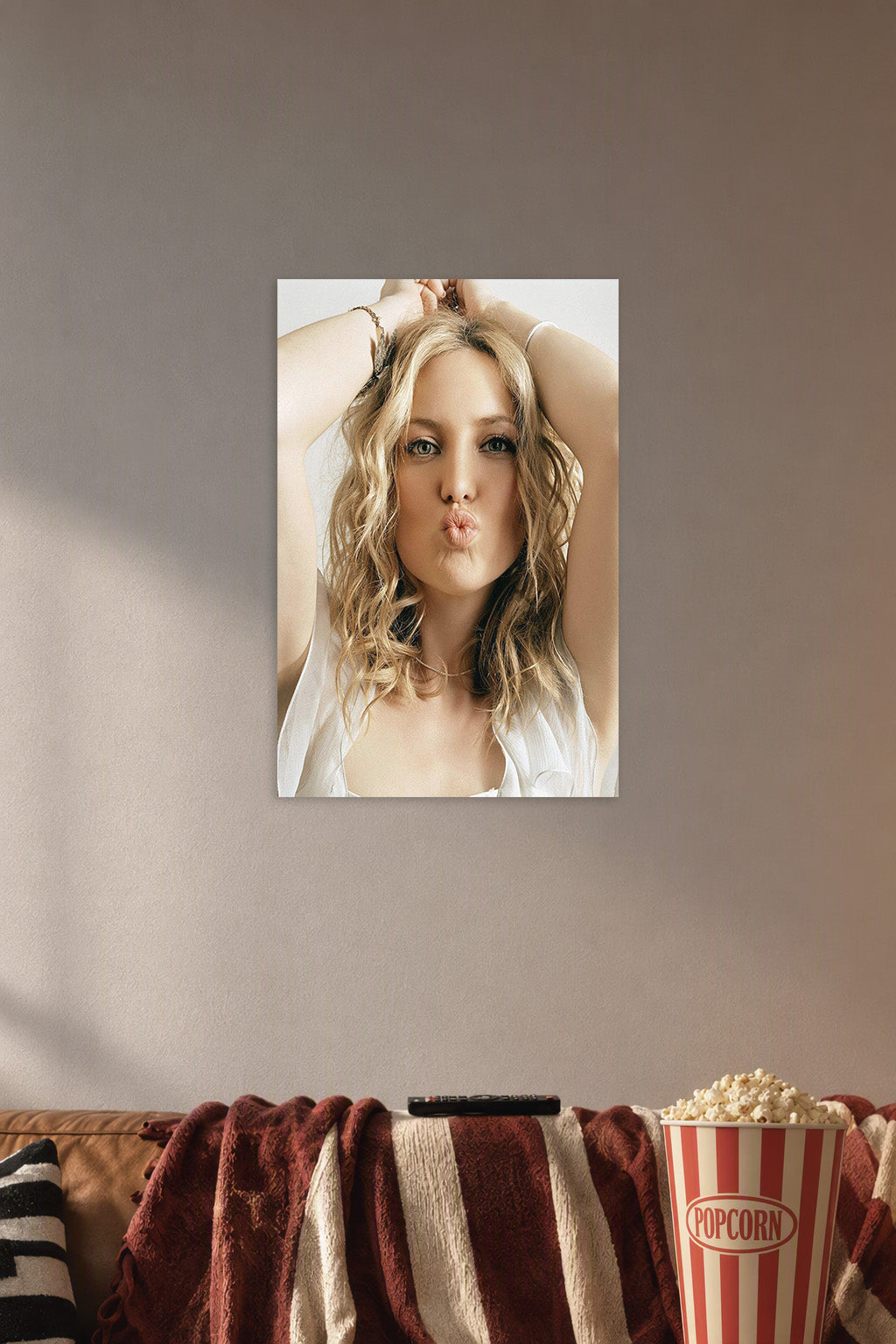 Kate Hudson in a cozy movie room above a brown sofa with popcorn.
