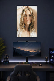 Kate Hudson in a gaming desk setup above a monitor.