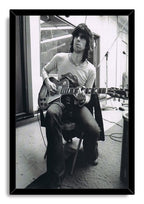 Keith Richards framed wall art print features a monochrome portrait of the seated guitarist playing electric guitar in a recording studio.