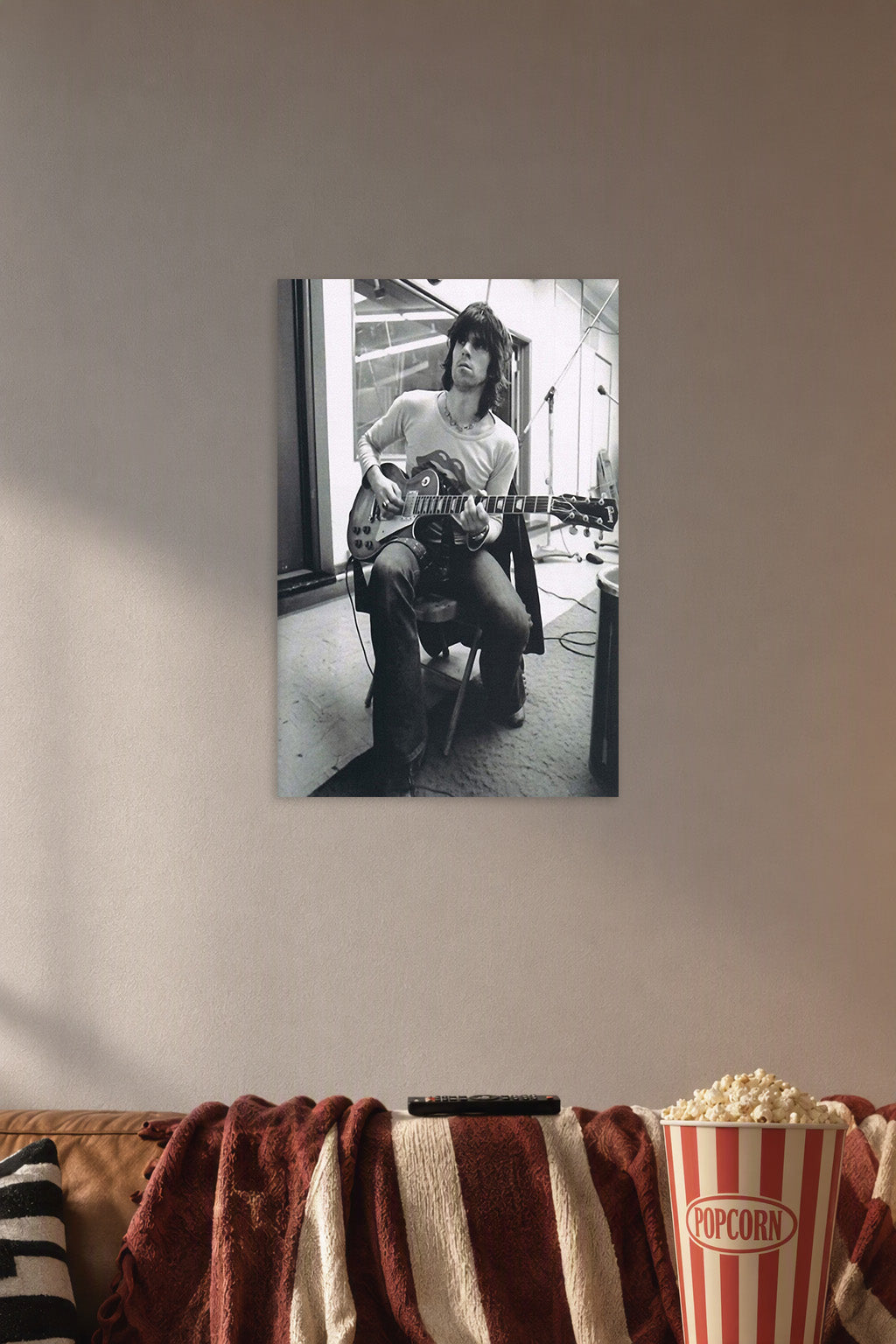 Keith Richards Rock Legend in a cozy movie room above a brown sofa with popcorn.