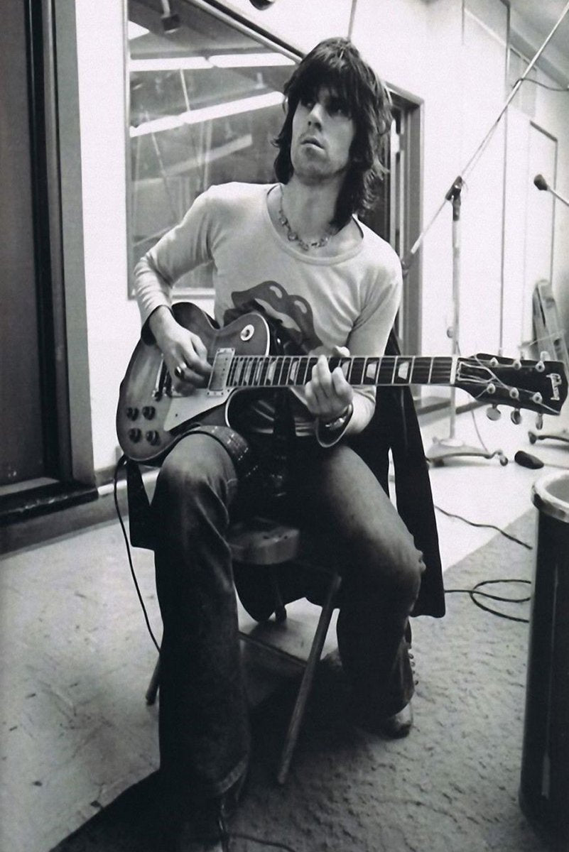 Keith Richards wall art print in black and white, seated playing an electric guitar amid studio microphones and cables.