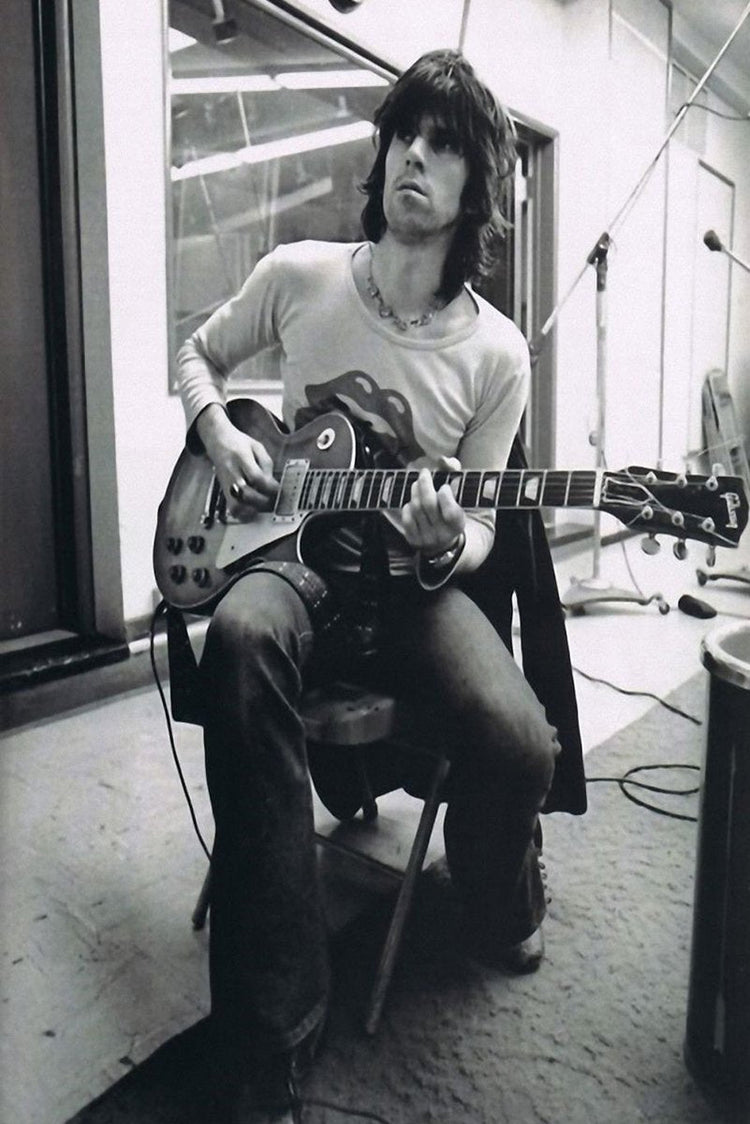 Keith Richards wall art print in black and white, seated playing an electric guitar amid studio microphones and cables.