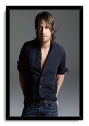 Keith Urban framed wall art print displays a studio portrait in a black frame, with dark shirt, jeans, and gray backdrop.
