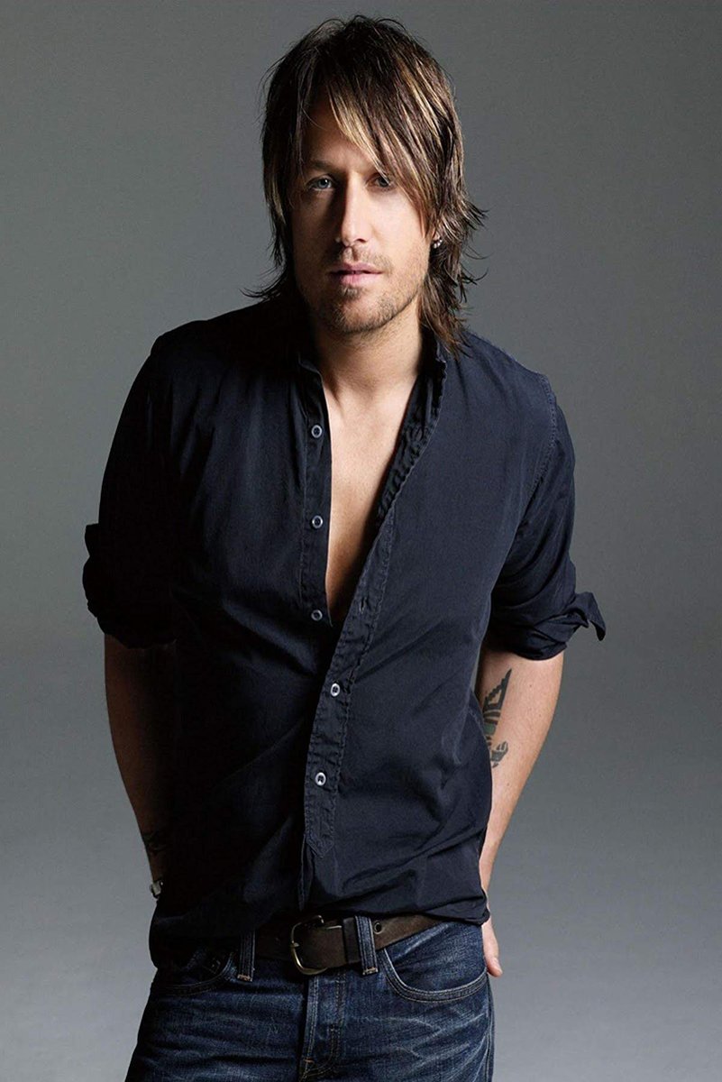 Keith Urban wall art print features a studio portrait of the musician in an open dark shirt and jeans against gray.