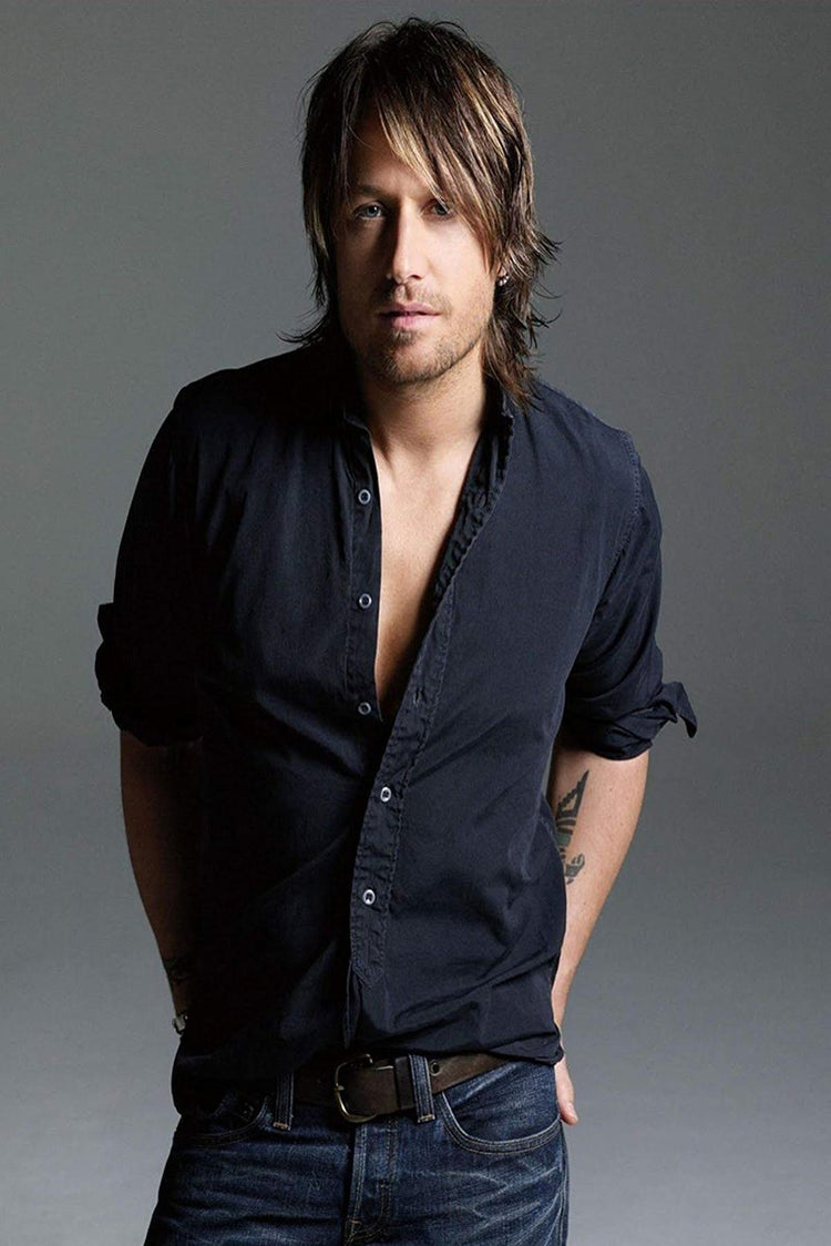 Keith Urban wall art print features a studio portrait of the musician in an open dark shirt and jeans against gray.