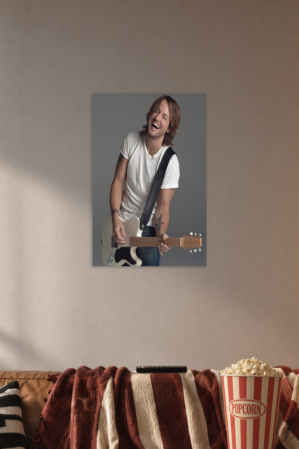 Keith Urban in a cozy movie room above a brown sofa with popcorn.