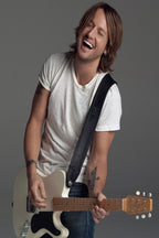 Keith Urban wall art print portrays the smiling musician in a white T-shirt playing a cream electric guitar against gray.