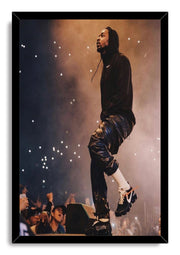Kendrick Lamar framed wall art print features the rapper performing in a black hoodie, with raised audience hands and glowing lights below.