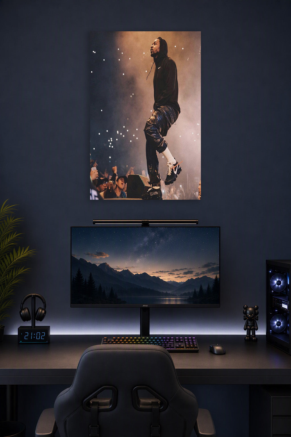 Kendrick Lamar in a gaming desk setup above a monitor.