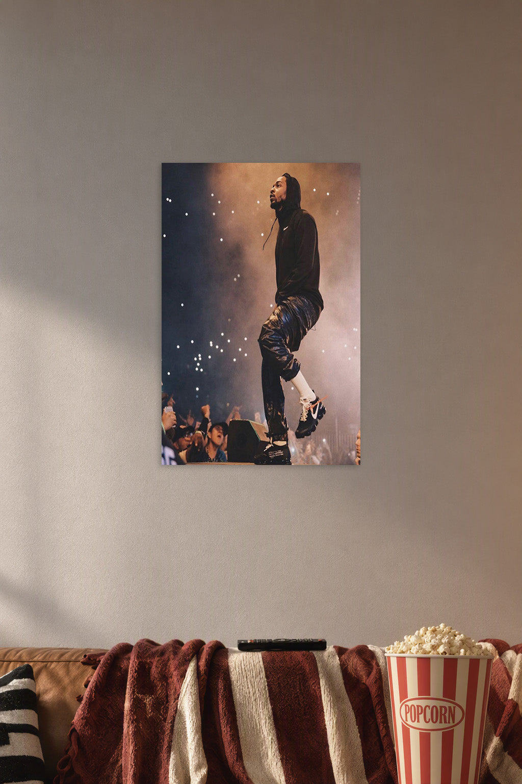 Kendrick Lamar in a cozy movie room above a brown sofa with popcorn.